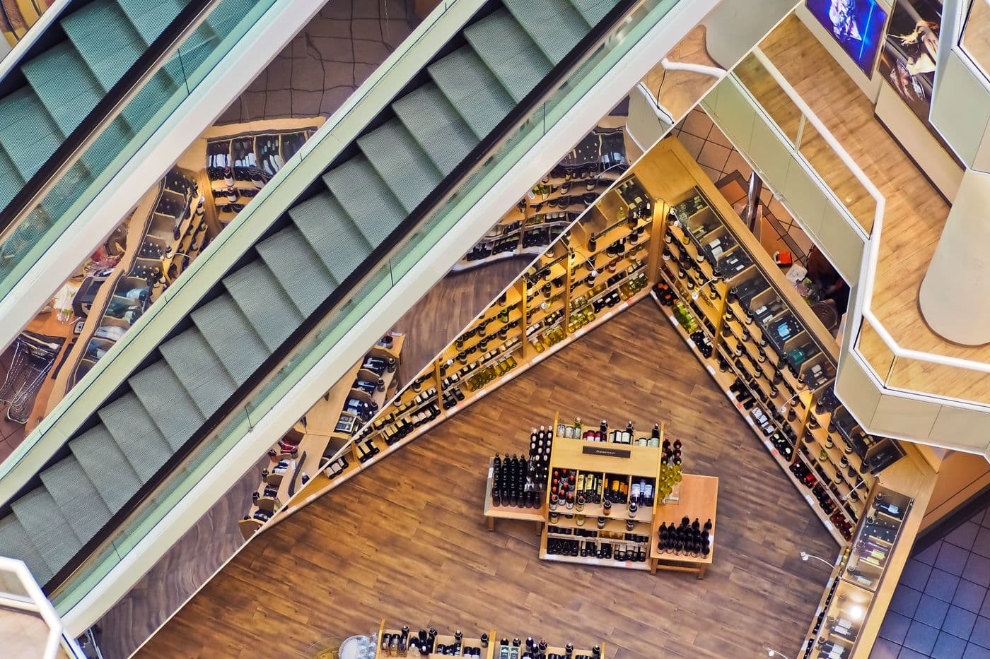 Intérieur d'une galerie commerçante vu de haut, escalators et rayonnages